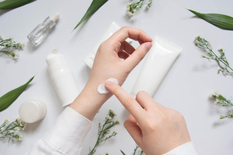 Person applying skin cream to hand