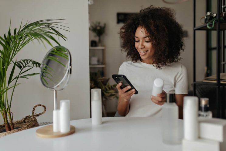 Woman reading eye cream ingredients