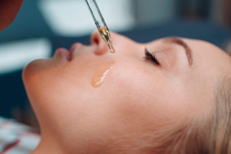 Woman using rejuvenating venom skincare oil