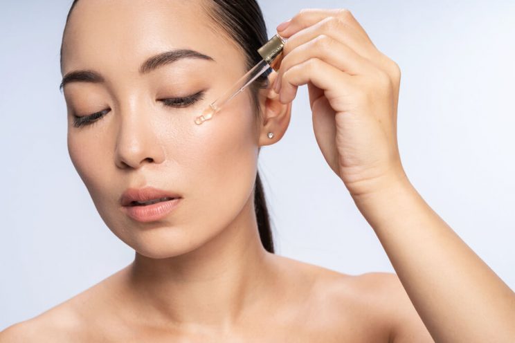 Woman applying eye serum