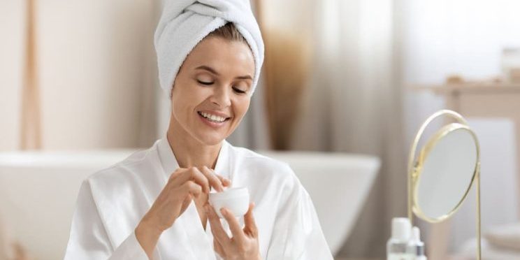 Woman applying daily moisturizer for aging skin