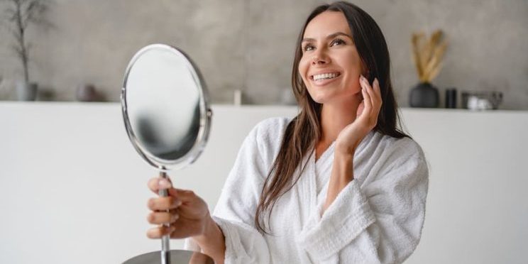 Woman looking at her skin results in the mirror