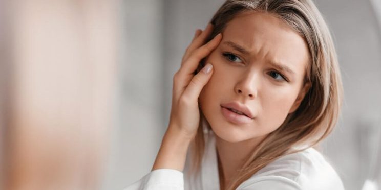concerned woman looking at skin